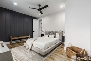 Hurricane house for rent - A bedroom with a bed, a bench, and a ceiling fan.