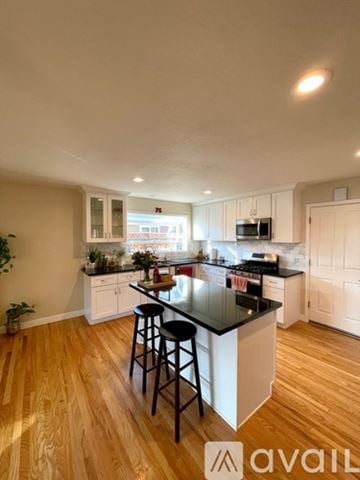 San Jose house for rent - A kitchen with a black countertop and white cabinets.