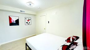 South Salt Lake apartment for rent - A bedroom with a white bed and two abstract paintings on the wall.