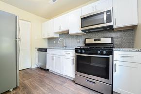 Bear townhouse for rent - A kitchen with white cabinets and stainless steel appliances.