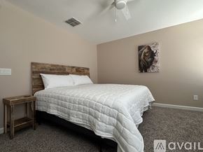 San Tan Valley house for rent - A bedroom with a bed, nightstand, and a painting on the wall.