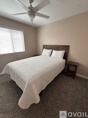 San Tan Valley house for rent - A bedroom with a bed, a ceiling fan, and a small table.