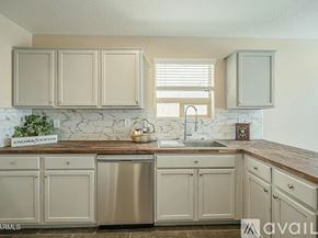 San Tan Valley house for rent - A kitchen with beige cabinets and a marble backsplash.