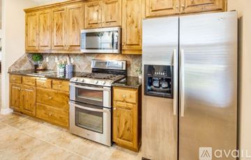 College Station house for rent - A kitchen with wooden cabinets and stainless steel appliances.