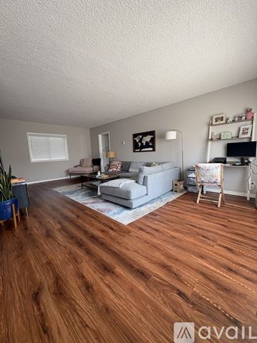 Santa Monica condo for rent - A living room with a grey couch and a wooden floor.