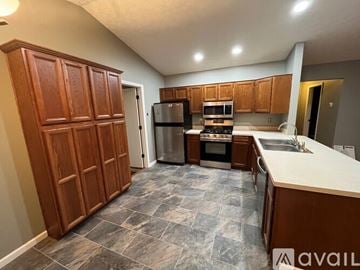 Columbus house for rent - A kitchen with wooden cabinets and a stone floor.