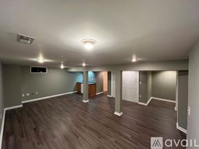 Columbus house for rent - A spacious room with wooden flooring and a flat screen TV mounted on the wall.