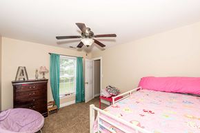 Jacksonville house for rent - A bedroom with a pink bed and a ceiling fan.