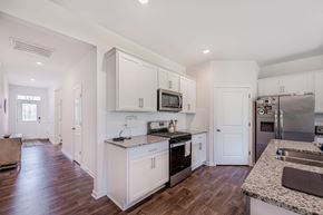 New Bern house for rent - A kitchen with white cabinets and a granite counter top.