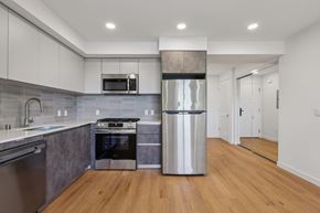 Los Angeles apartment for rent - A modern kitchen with a stainless steel refrigerator and wooden floors.
