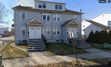 Linden apartment for rent - A two-story house with a grey facade and white trim.
