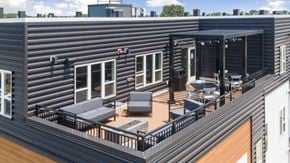 Fridley apartment for rent - A balcony with a table and chairs is on the roof of a building.