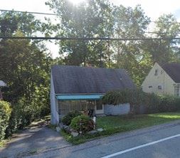 Penn Hills house for rent - A house with a blue awning is surrounded by greenery.