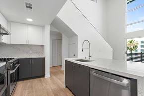 Burbank apartment for rent - A modern kitchen with a stainless steel dishwasher and a white countertop.