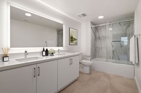 Burbank apartment for rent - A modern bathroom with a large mirror, a sink, a toilet, and a bathtub.