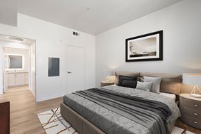 Burbank apartment for rent - A bedroom with a large bed and a painting on the wall.