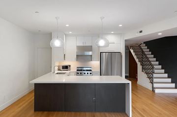 San Francisco apartment for rent - A modern kitchen with a white island and stainless steel appliances.