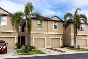 Clearwater house for rent - A row of houses with garages and palm trees in front.