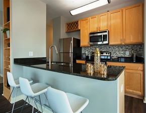 Clayton apartment for rent - a kitchen with a counter with chairs and a sink