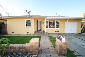 Escondido apartment for rent - A yellow house with a grey roof and a white door.