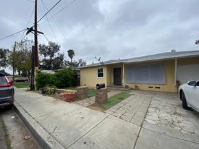 Escondido apartment for rent - A house with a yellow exterior and a white car parked in front.