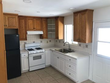 Escondido apartment for rent - A kitchen with white appliances and wooden cabinets.