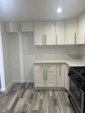 Glendale apartment for rent - A kitchen with a black stove top oven and white cabinets.