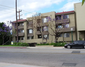 Glendale apartment for rent - A black car is parked on the side of a street in front of a building with a tree in front of it.