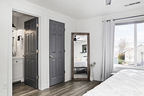Grants Pass house for rent - A bedroom with a large bed and a mirror on the wall.