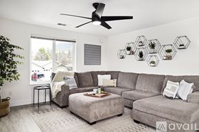 Grants Pass house for rent - A living room with a grey couch, a small table, and a plant.
