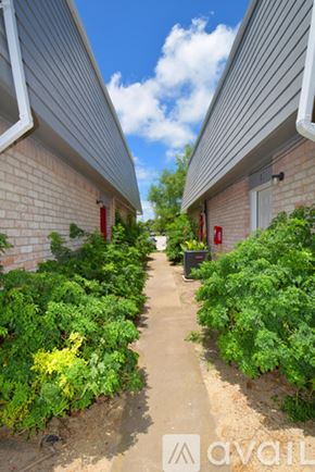 Ingleside apartment for rent - A narrow pathway between two buildings with a sign that reads "AVAIL" in the foreground.