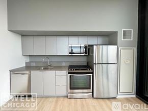 Chicago apartment for rent - A modern kitchen with stainless steel appliances and white cabinets.