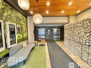 Chicago apartment for rent - A modern living room with a stone wall and a green carpet.