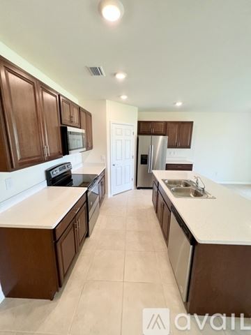 Cape Coral house for rent - A kitchen with brown cabinets and a white counter.