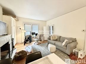Boston apartment for rent - A living room with a white coffee table and a television on the wall.