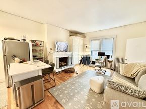 Boston apartment for rent - A kitchen with white cabinets and a refrigerator with magnets on it.