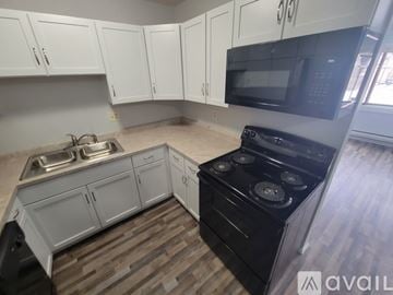 La Crosse apartment for rent - A kitchen with white cabinets and a black stove top oven.