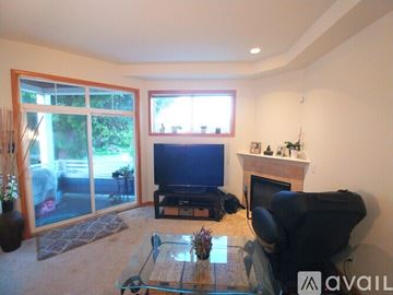Seattle house for rent - A living room with a glass coffee table and a black leather chair.