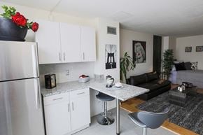 Bethesda apartment for rent - a kitchen and living room with white cabinets and a granite counter top