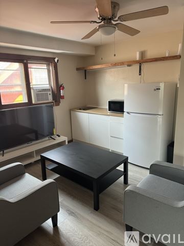 Milwaukee apartment for rent - A living room with a black table and grey chairs.