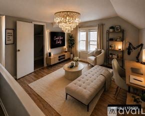 Cleveland Heights house for rent - A living room with a couch, a coffee table, a TV, and a chandelier.