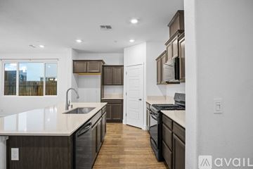 Merced house for rent - A modern kitchen with dark wood cabinets and a white countertop.