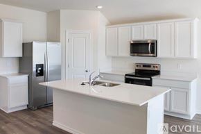 Highfill house for rent - A kitchen with white cabinets and appliances.