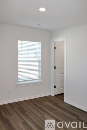 Highfill house for rent - A room with a window and wooden flooring.