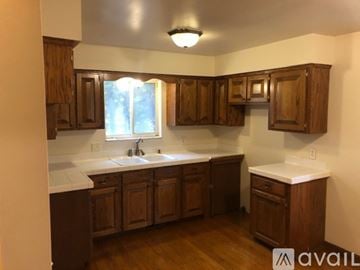 Village Of Clarkston house for rent - A kitchen with wooden cabinets and a window.