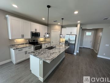Mesa house for rent - A kitchen with a granite countertop and white cabinets.