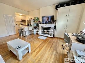 Boston apartment for rent - A living room with a white coffee table and a television on the wall.