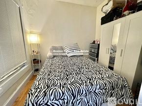 Boston apartment for rent - A bedroom with a zebra print bedspread and a white wardrobe.