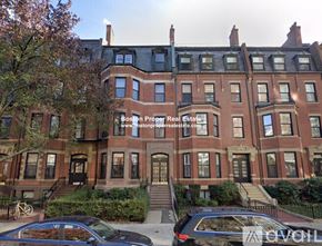 Boston apartment for rent - A large red brick building with a black car parked in front.