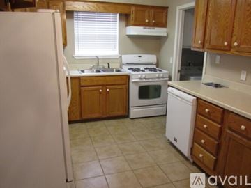 Oklahoma City house for rent - A kitchen with wooden cabinets and a white refrigerator.